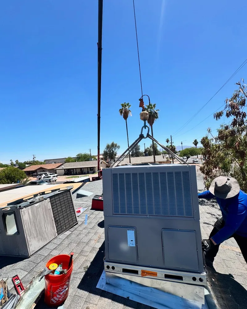 Crane hoisting package unit onto rooftop